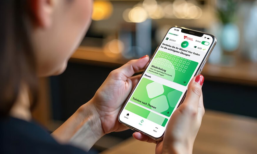Frau sitzt in Bar und hält Smartphone mit VogelCheck in der Hand