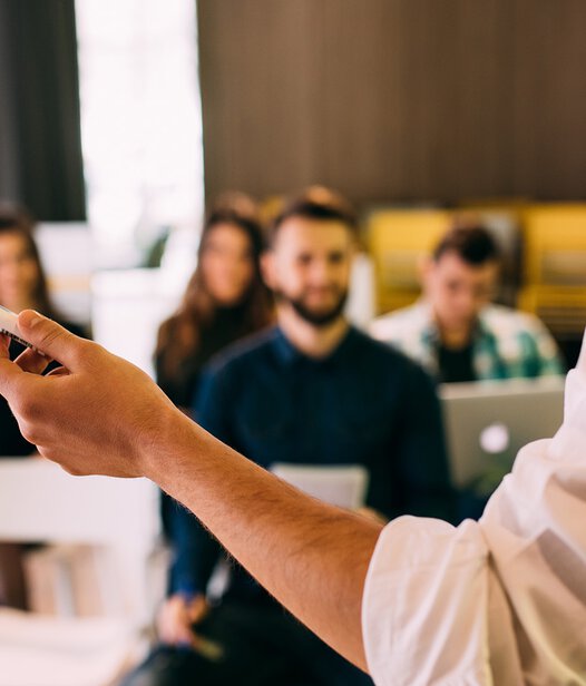 Mit PC Professional unterrichten Sie am Puls der Zeit. In der Cloud und mit der Vogel BKF App Seminarleiter steht vor Gruppe von Menschen und hält einen Stift in der Hand
