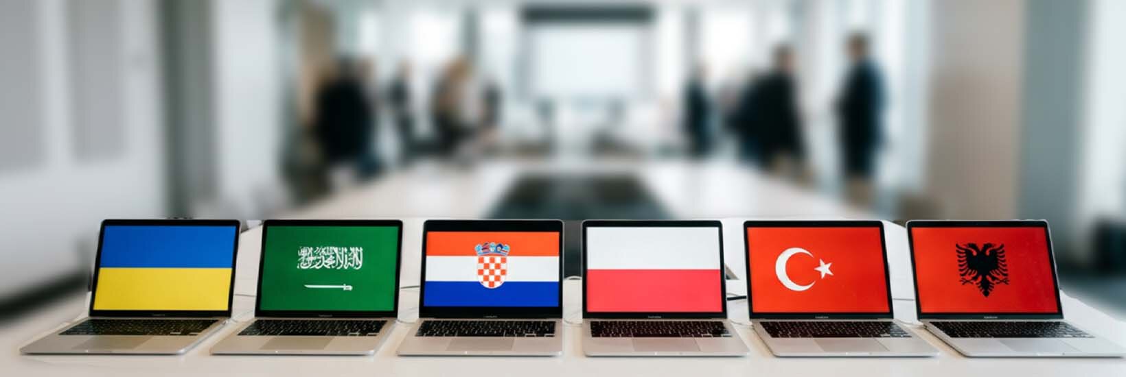 BKF-Prüfung in neun Fremdsprachen möglich Laptops mit Flaggen stehen in einer Reihe auf dem Schreibtisch